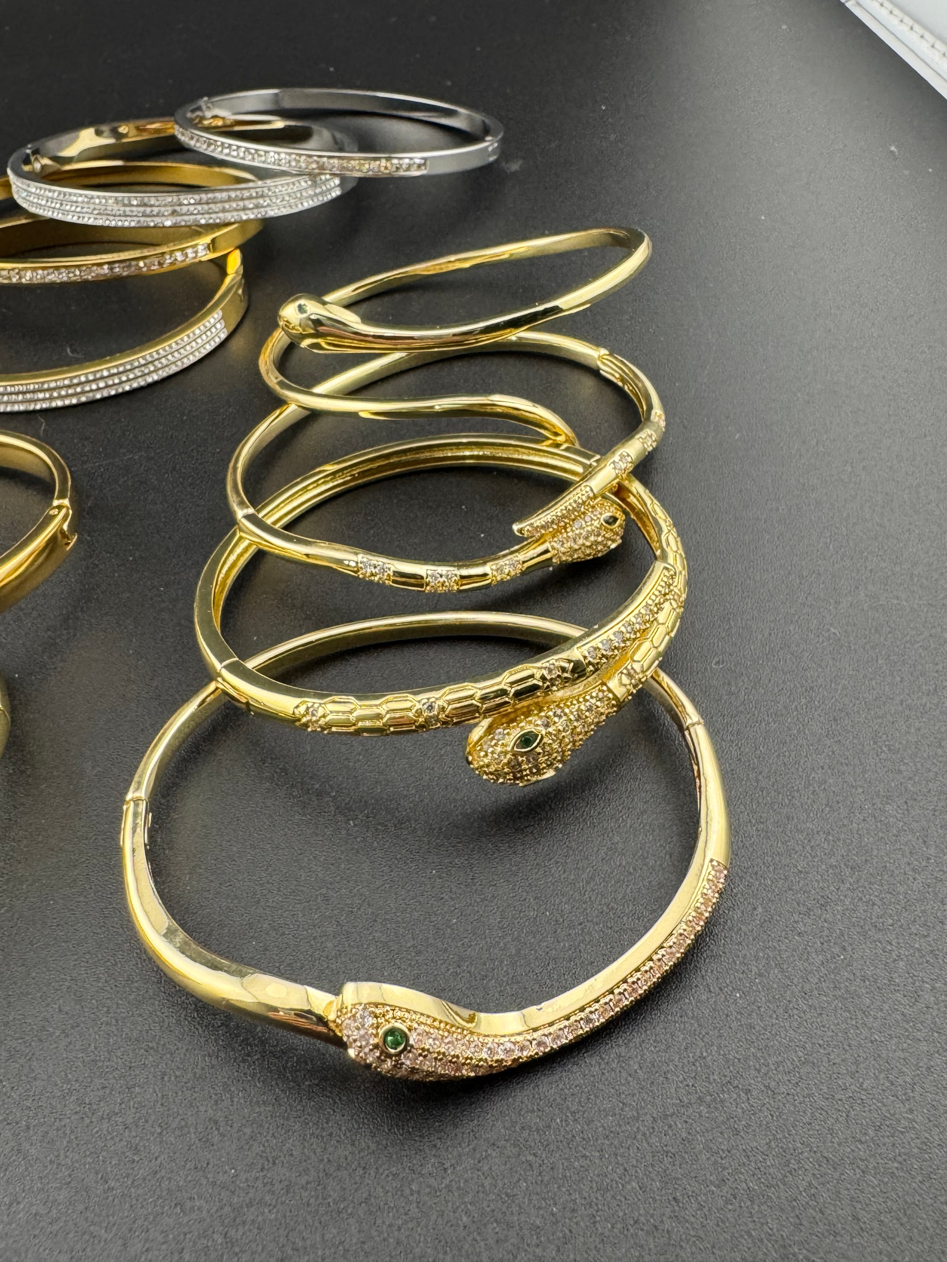 Small gold tone snake hoop earrings with CZ emerald eyes