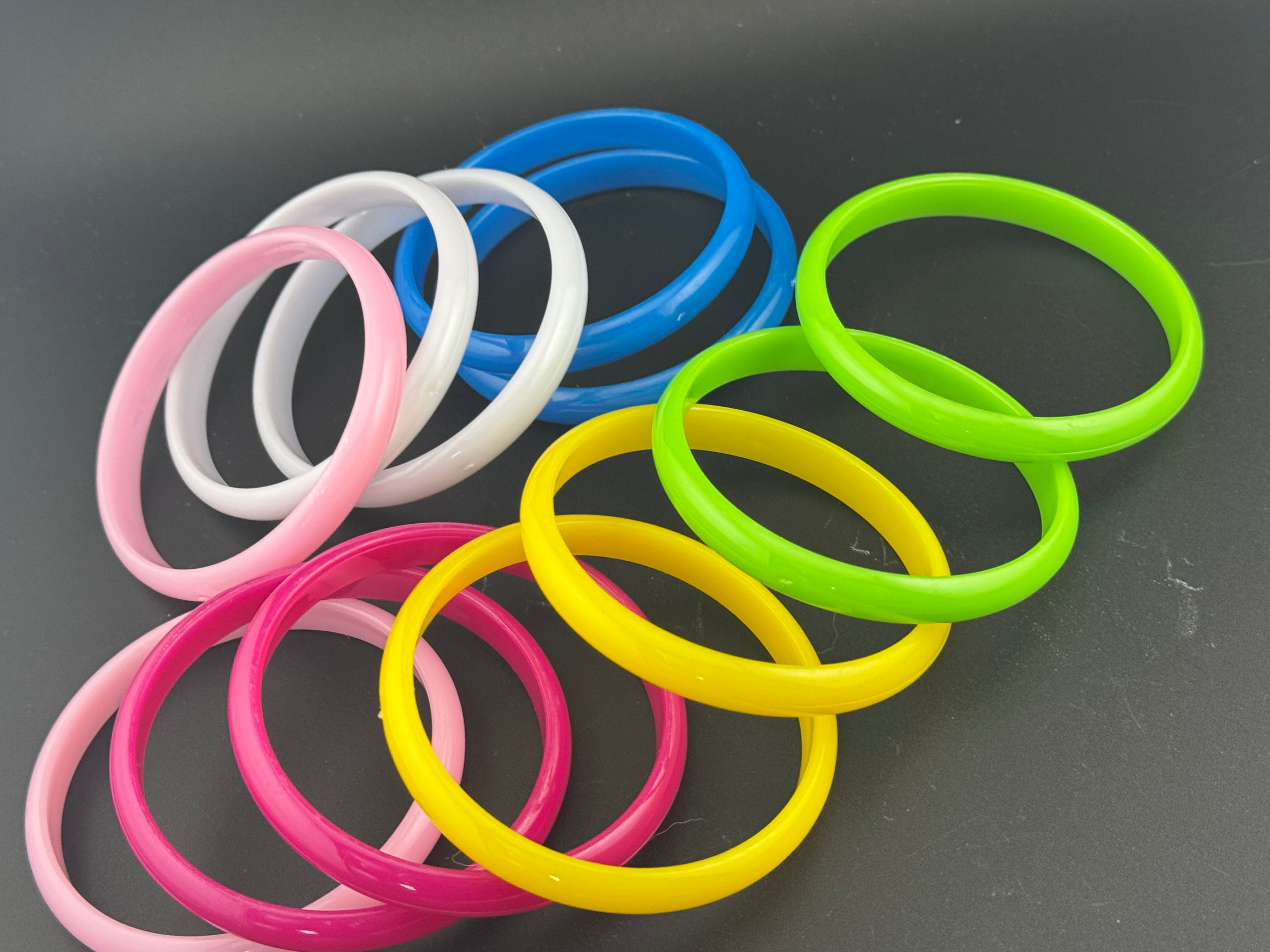 Stack of 12 coloured acrylic stacking bangles in baby pink yellow bright pink blue white green