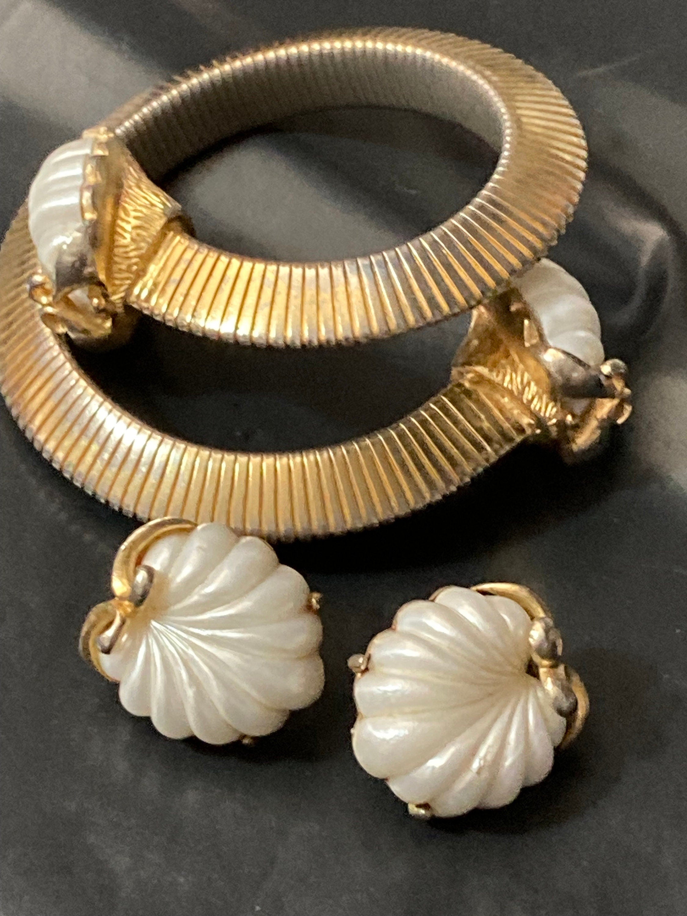 Signed JEWELCRAFT modernist gold tone white lucite shell cabochon omega wrap bangle bracelet and matching clip on earrings jewellery set