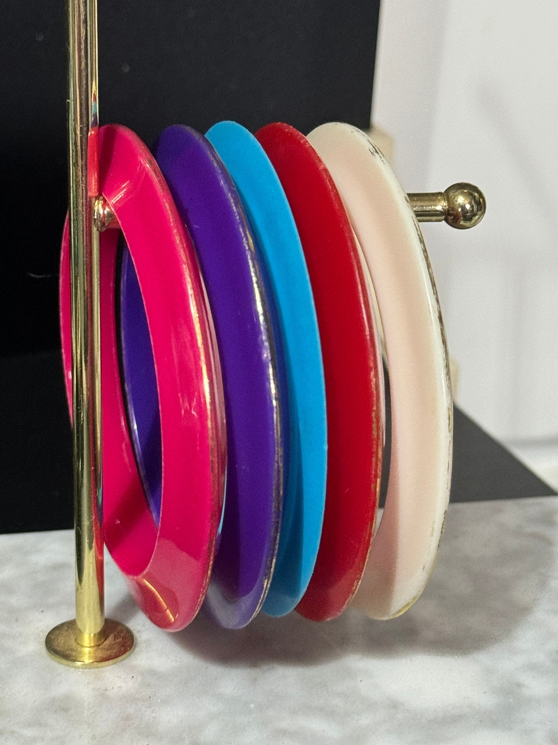 Vintage stack of coloured red purple blue cream pink plastic bangles retro acrylic bracelets