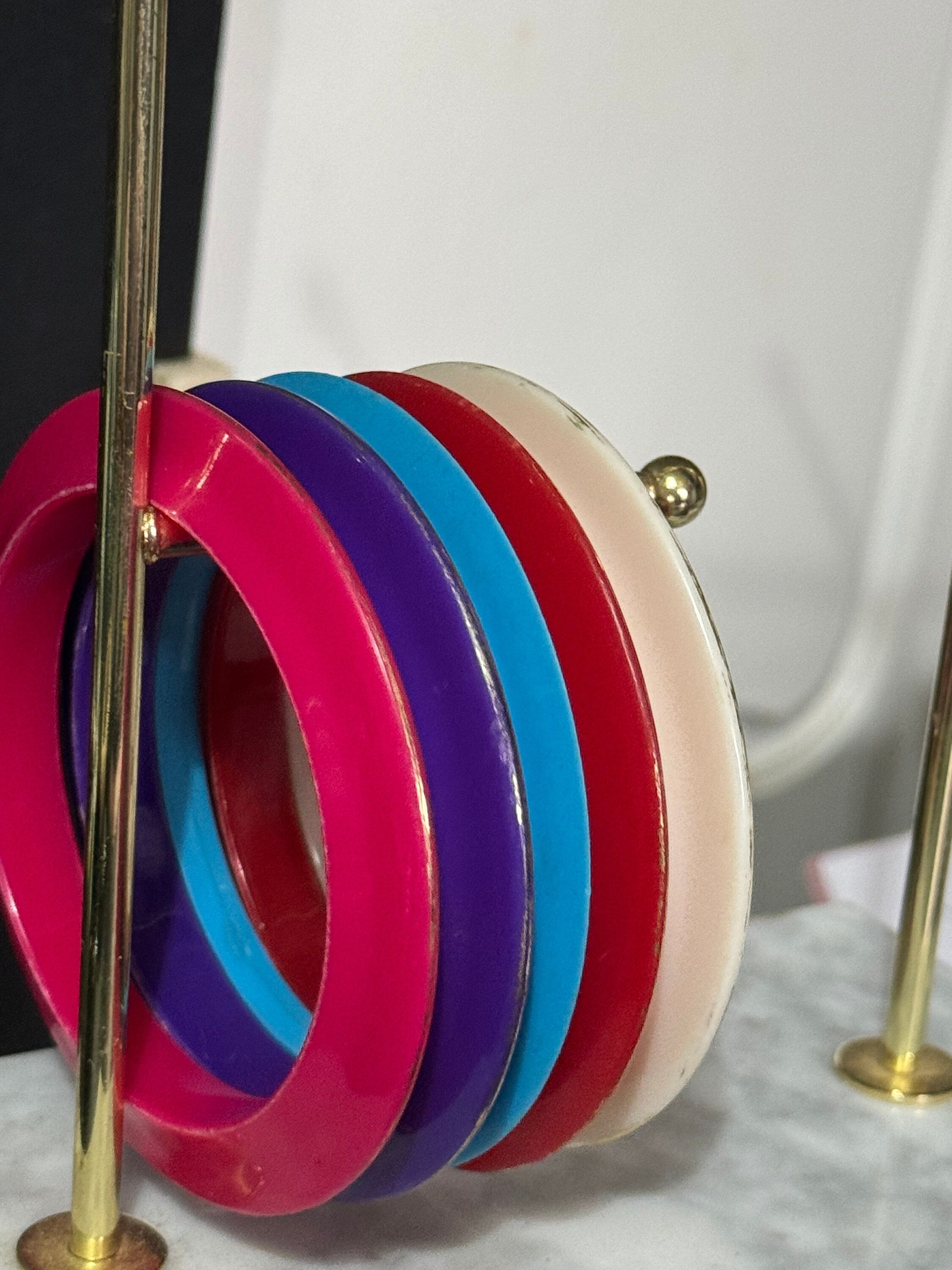 Vintage stack of coloured red purple blue cream pink plastic bangles retro acrylic bracelets