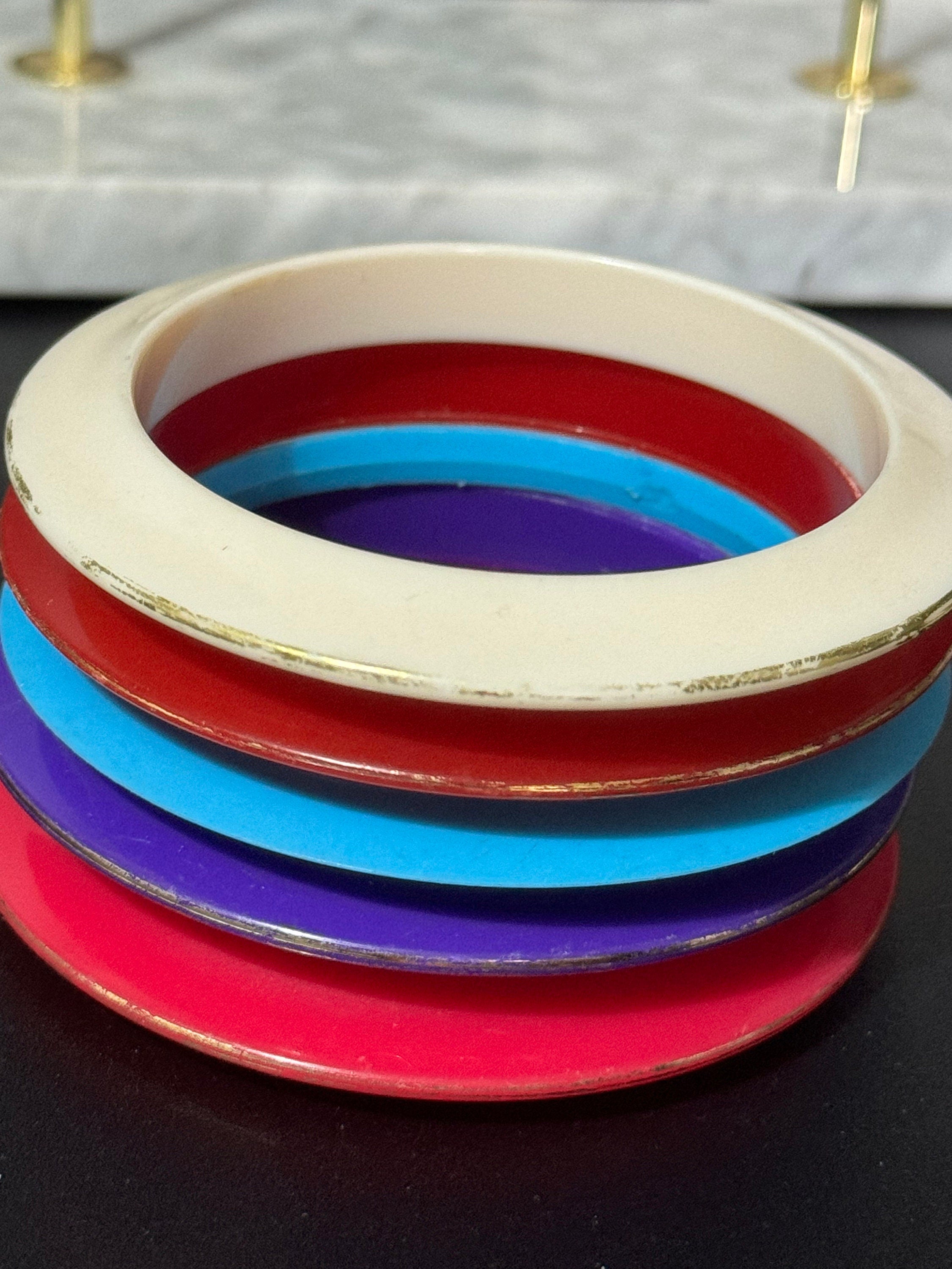 Vintage stack of coloured red purple blue cream pink plastic bangles retro acrylic bracelets