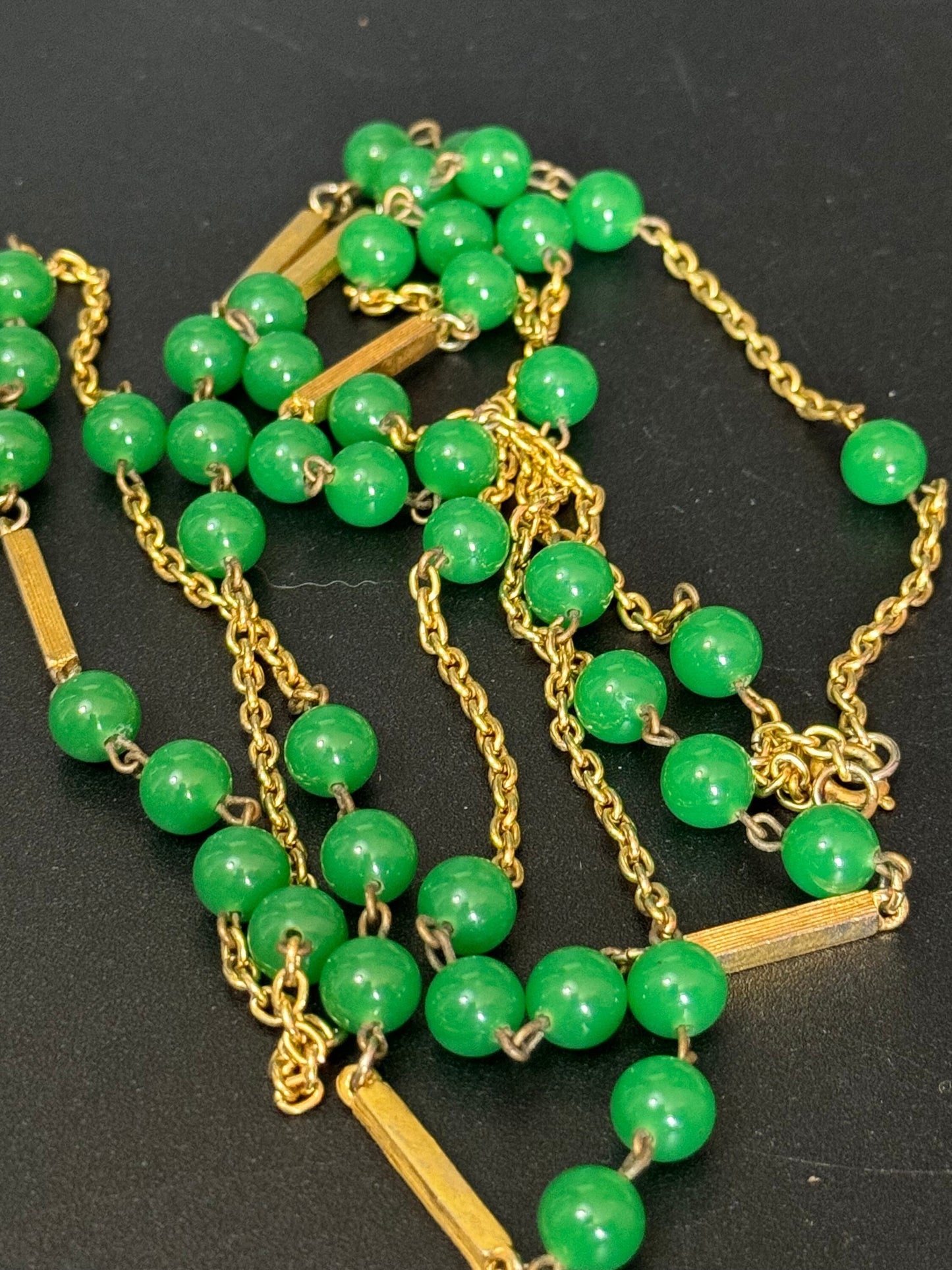 1970s flapper length gold tone metal necklace with bright green jade or glass beads 120cm modernist